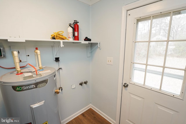 laundry room featuring electric water heater and hardwood / wood-style flooring