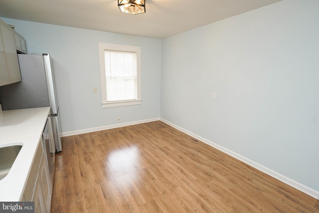 unfurnished dining area with sink and light hardwood / wood-style flooring