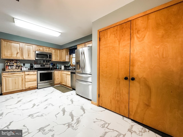 kitchen with appliances with stainless steel finishes, light brown cabinets, and sink