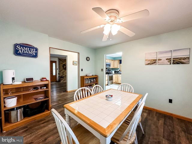 dining space featuring ceiling fan and dark hardwood / wood-style floors