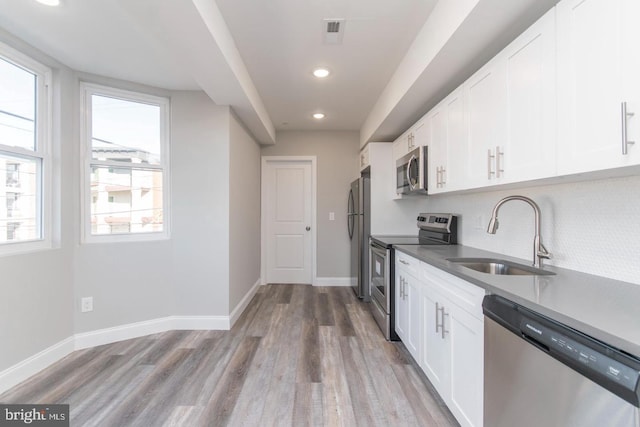 kitchen featuring white cabinets, light wood-type flooring, sink, and appliances with stainless steel finishes