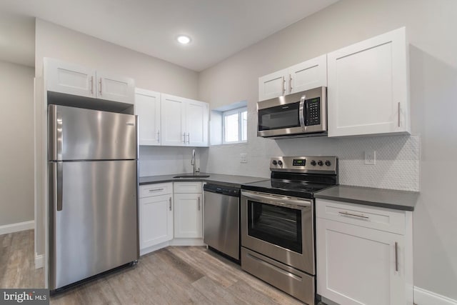 kitchen with white cabinets, sink, light wood-type flooring, and stainless steel appliances