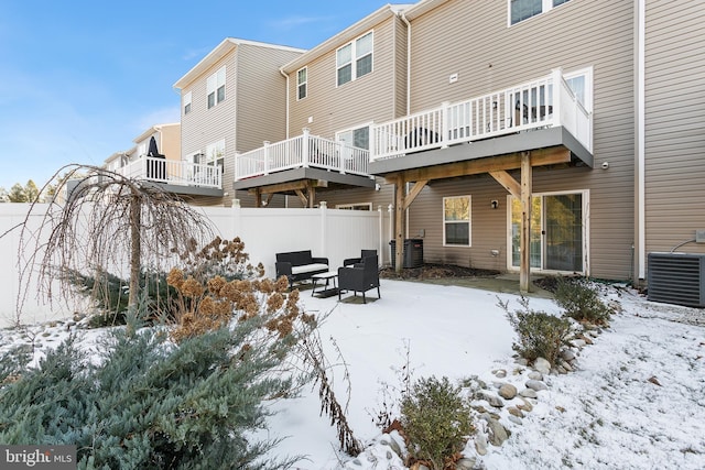 snow covered house featuring central AC