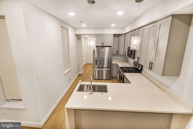 kitchen with pendant lighting, sink, gray cabinets, appliances with stainless steel finishes, and kitchen peninsula