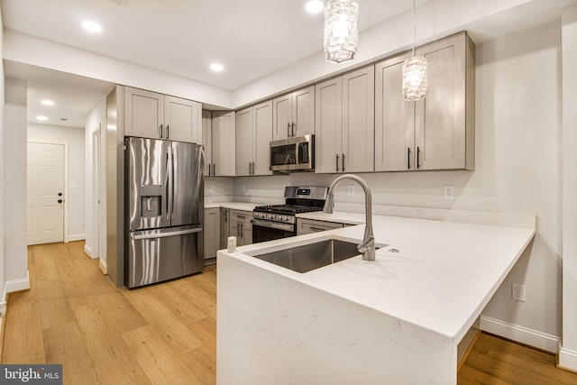 kitchen with pendant lighting, gray cabinets, and stainless steel appliances