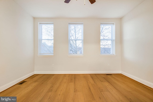 empty room with light hardwood / wood-style flooring, plenty of natural light, and ceiling fan