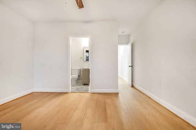 unfurnished bedroom featuring ensuite bathroom, light hardwood / wood-style flooring, and ceiling fan