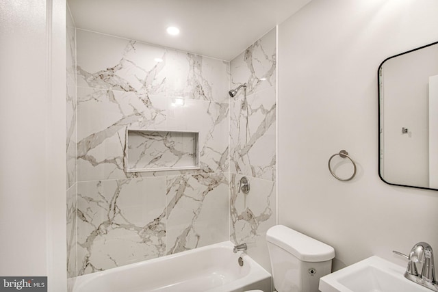 full bathroom with tiled shower / bath combo, toilet, and sink