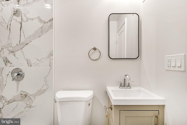 bathroom featuring vanity, toilet, and a shower