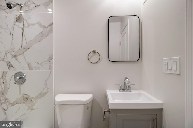 bathroom with walk in shower, vanity, and toilet