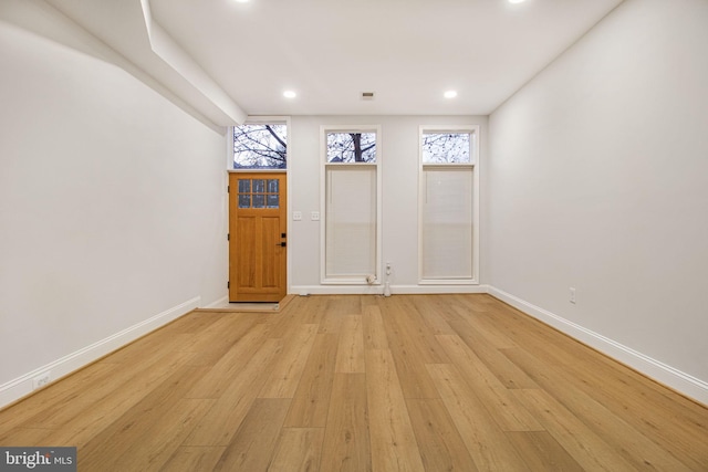 empty room with light hardwood / wood-style flooring and a healthy amount of sunlight