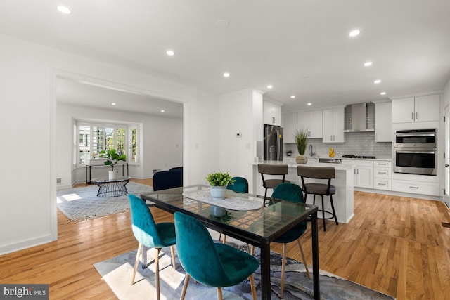 dining area with sink and light hardwood / wood-style flooring