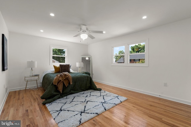 bedroom featuring multiple windows, ceiling fan, and light hardwood / wood-style floors