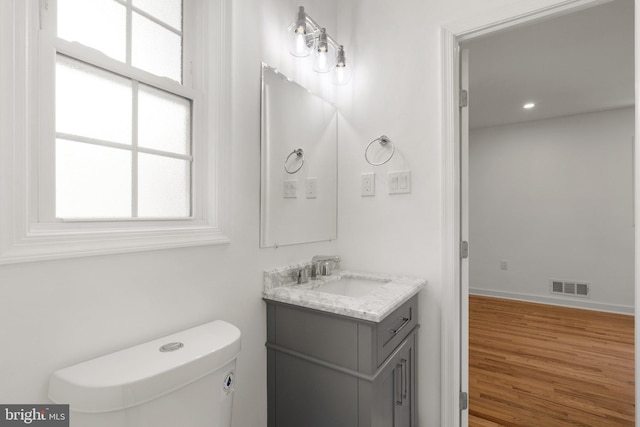 bathroom featuring hardwood / wood-style floors, vanity, toilet, and a wealth of natural light