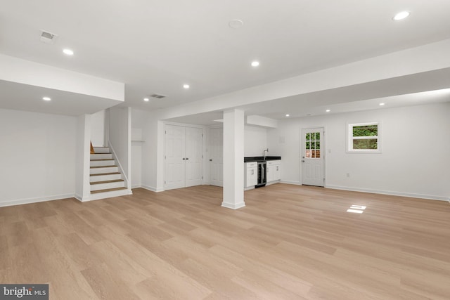 basement with light wood-type flooring and sink