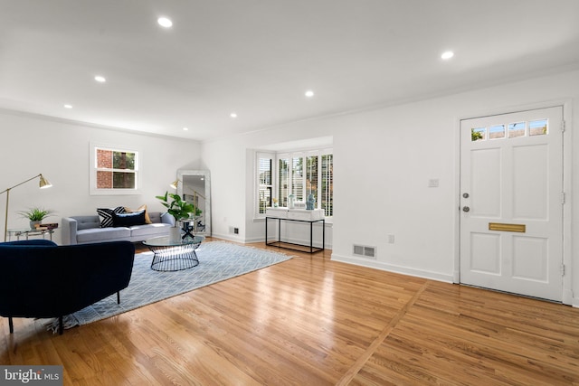 living room featuring light wood-type flooring and ornamental molding