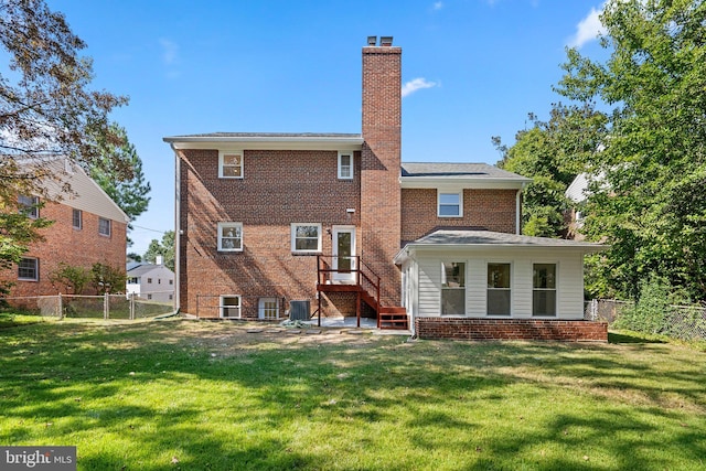 back of property featuring central air condition unit and a yard