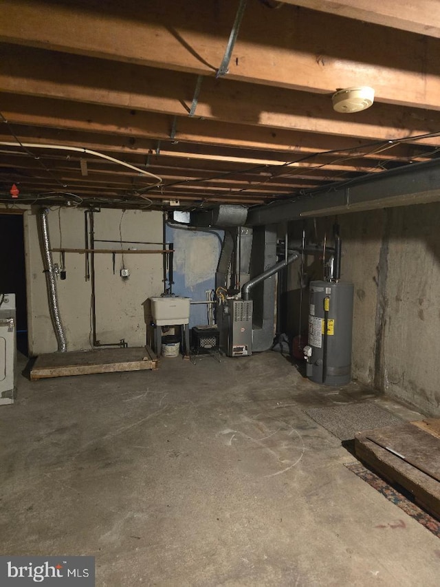 basement with heating unit, sink, gas water heater, and washer / dryer