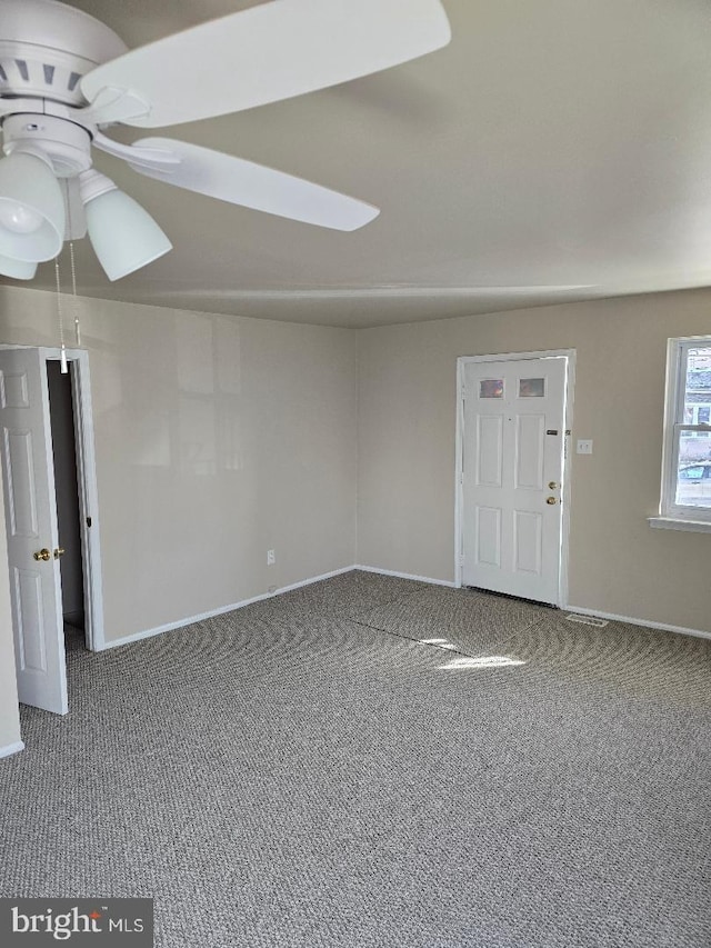 carpeted spare room featuring ceiling fan