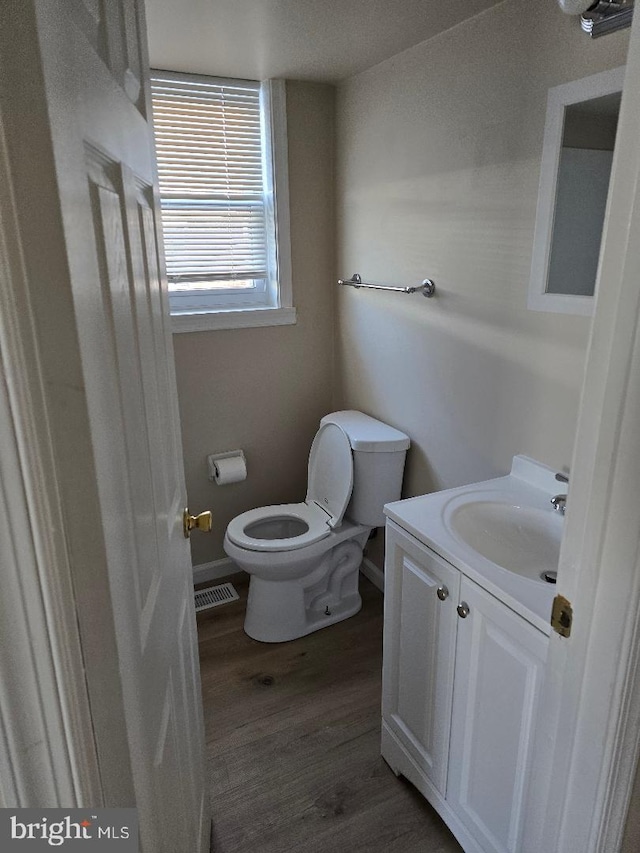 bathroom featuring vanity, wood-type flooring, and toilet