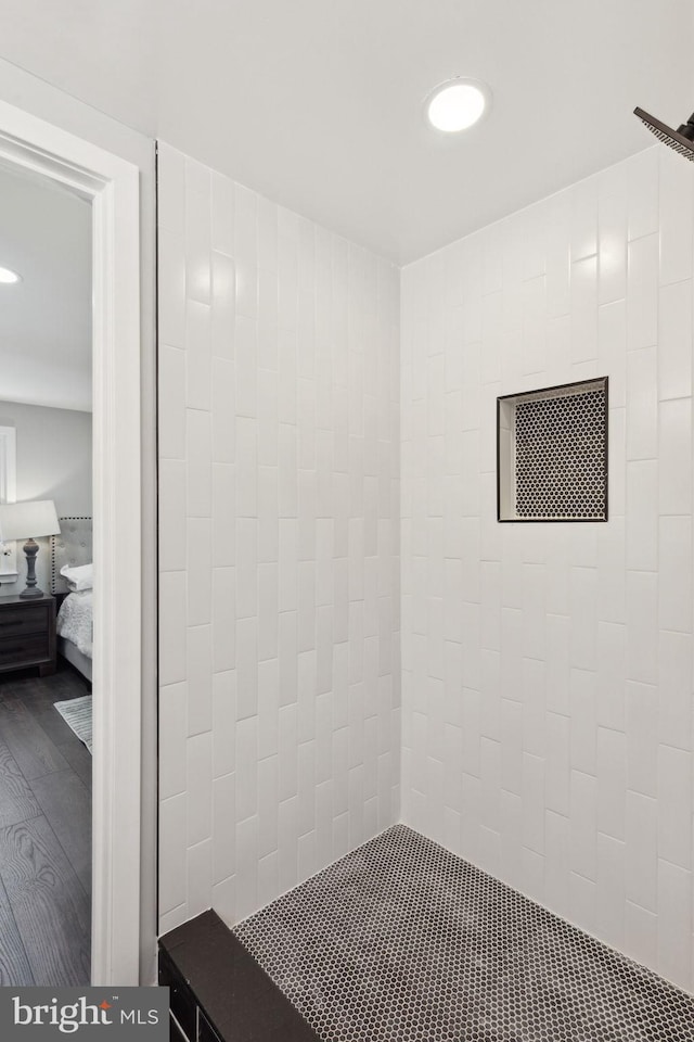 bathroom featuring hardwood / wood-style floors and tiled shower