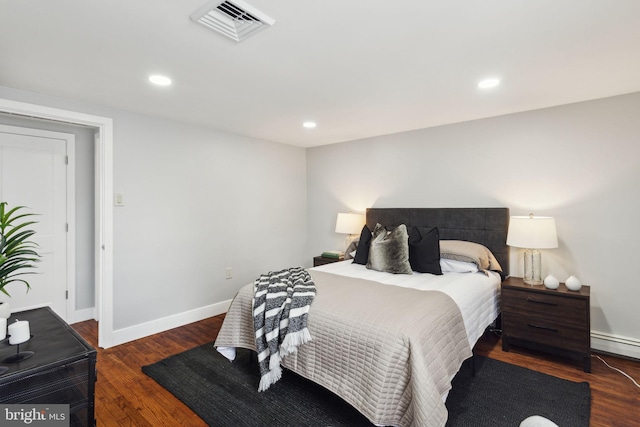 bedroom featuring dark hardwood / wood-style floors and a baseboard heating unit