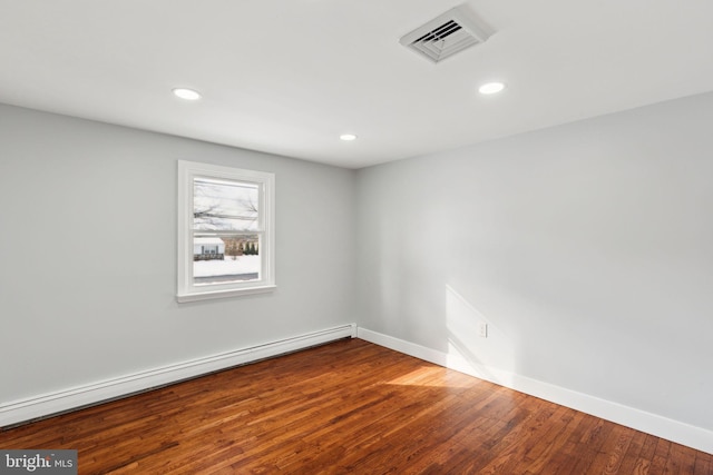 spare room with a baseboard radiator and hardwood / wood-style flooring