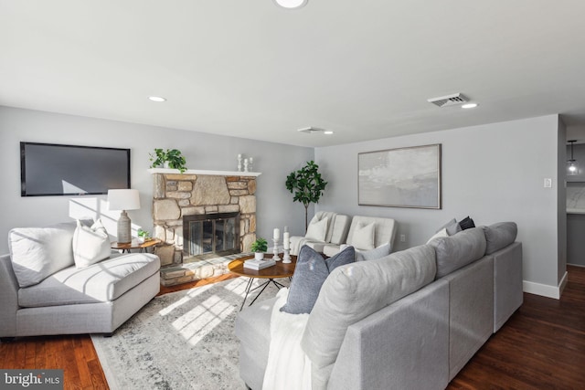 living room with dark hardwood / wood-style flooring and a fireplace