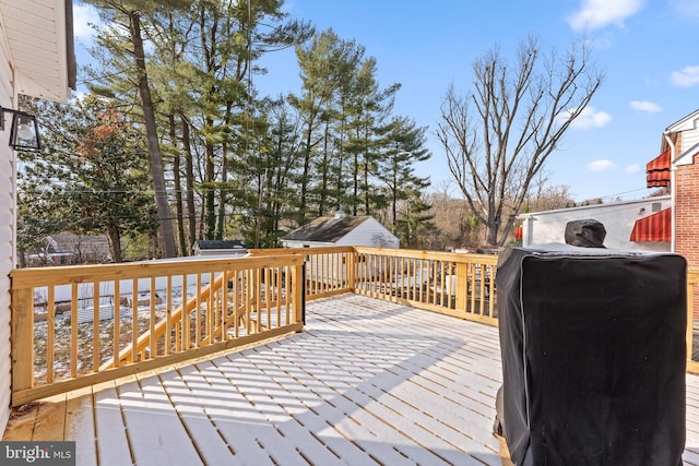 wooden deck with grilling area and a storage shed