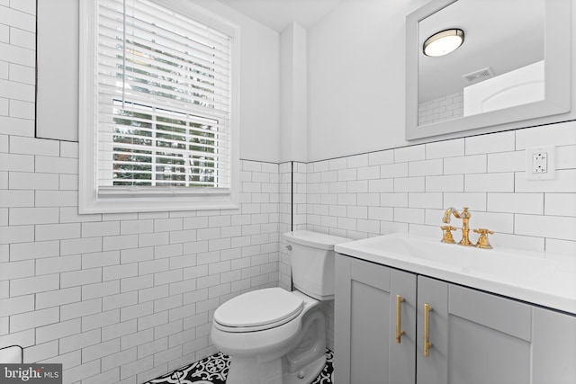 bathroom featuring tile walls, vanity, and toilet