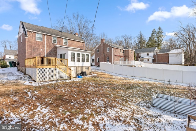 snow covered property with central AC and a wooden deck