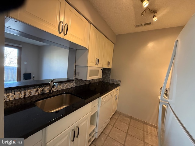 kitchen featuring tasteful backsplash, sink, white cabinets, and white appliances