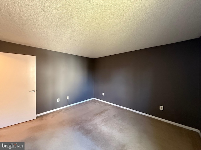 carpeted empty room with a textured ceiling