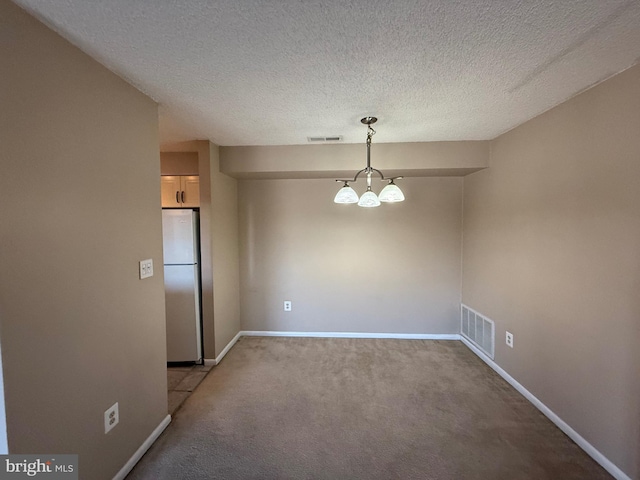 unfurnished dining area featuring carpet, a textured ceiling, and a notable chandelier