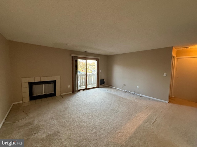 unfurnished living room with a fireplace, light colored carpet, and a textured ceiling