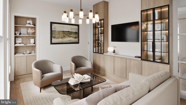 living room featuring light hardwood / wood-style flooring, built in features, and a notable chandelier