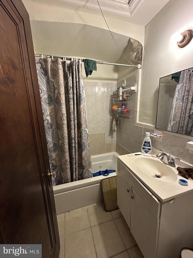 bathroom featuring tile patterned flooring, vanity, shower / bath combo with shower curtain, and tile walls