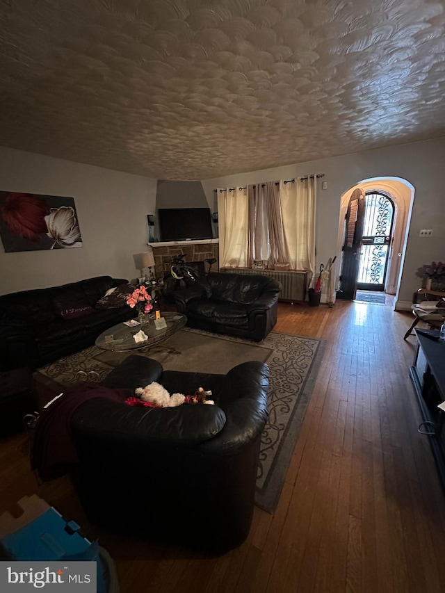 living room featuring a fireplace, hardwood / wood-style floors, and a textured ceiling