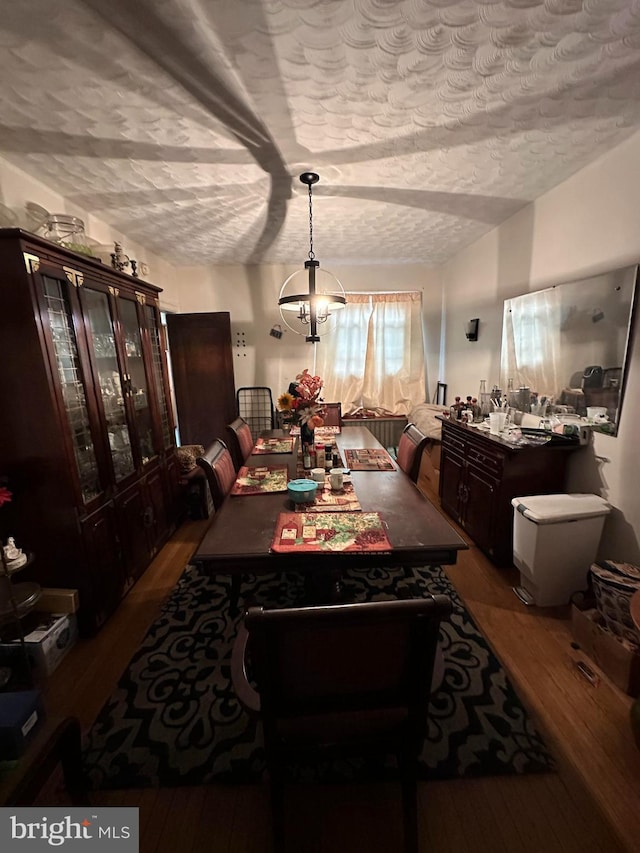 dining room featuring a chandelier, hardwood / wood-style floors, and a textured ceiling