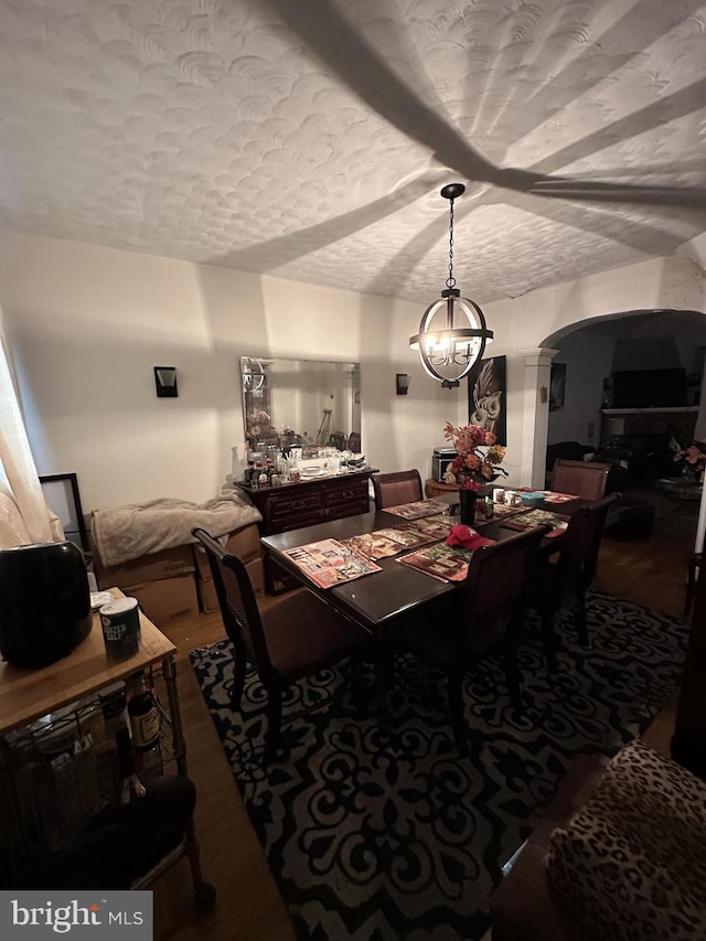 dining room featuring hardwood / wood-style floors, a textured ceiling, and an inviting chandelier