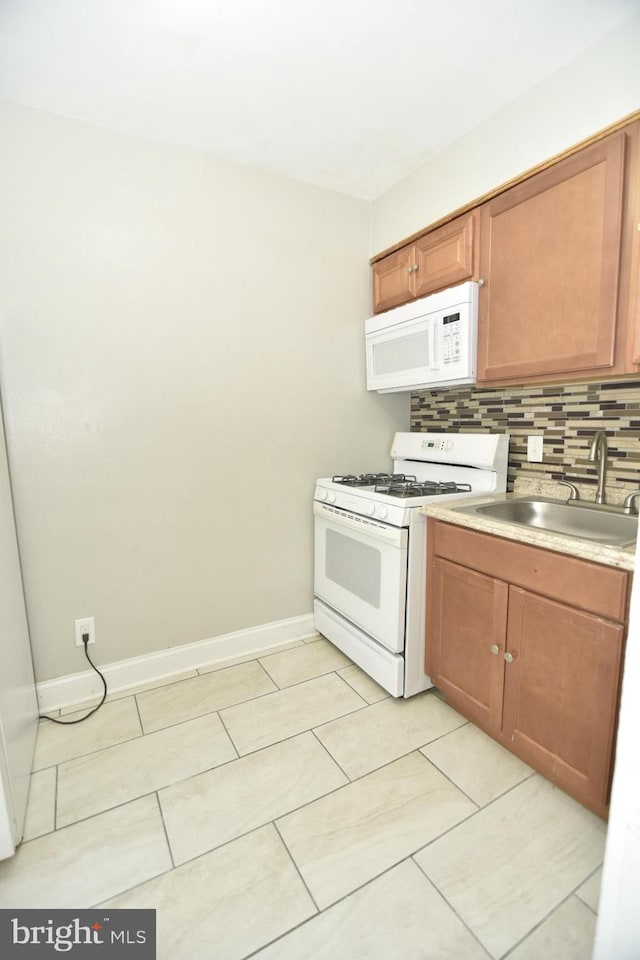 kitchen with backsplash, sink, and white appliances