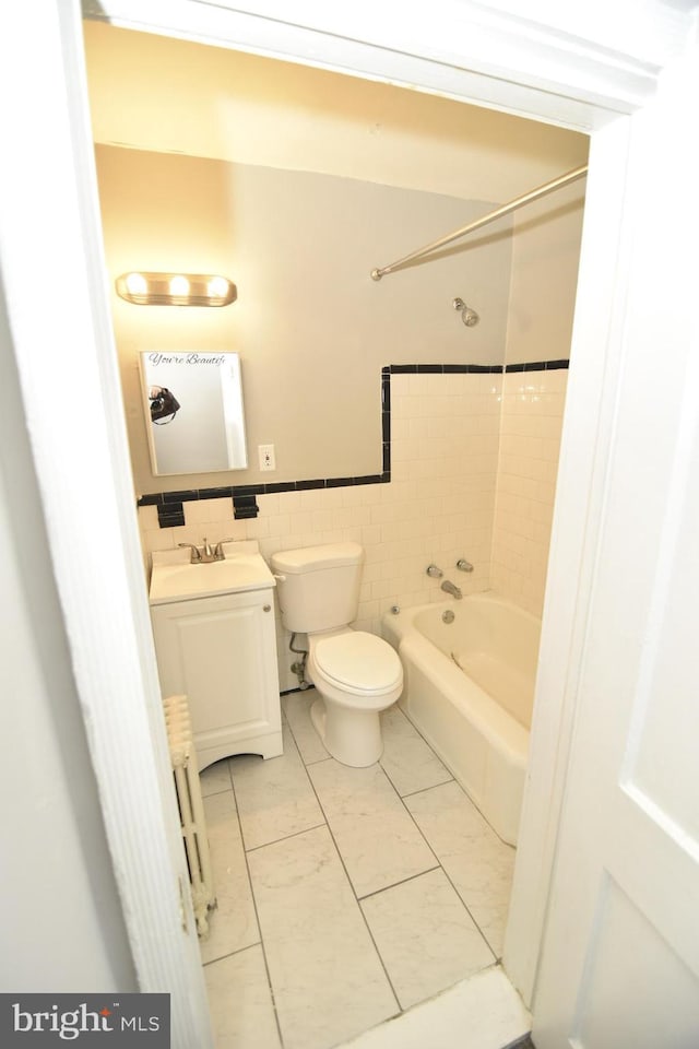 full bathroom with tile patterned floors, tiled shower / bath combo, tile walls, radiator heating unit, and toilet