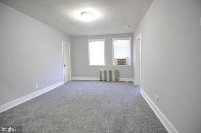 spare room featuring carpet floors, radiator, and cooling unit