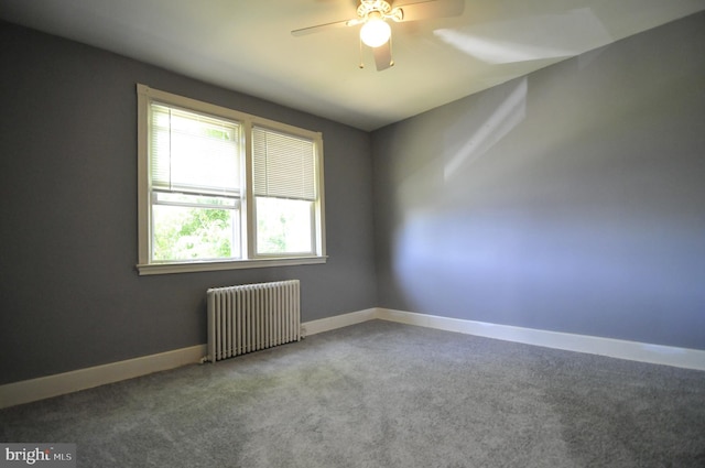 carpeted empty room featuring radiator and ceiling fan