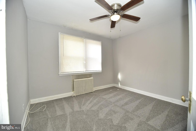 carpeted empty room featuring radiator and ceiling fan