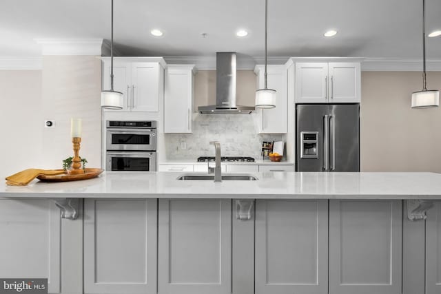 kitchen with wall chimney range hood, hanging light fixtures, stainless steel appliances, light stone countertops, and white cabinets