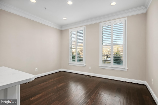 empty room with ornamental molding and dark hardwood / wood-style flooring