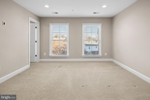 spare room featuring light carpet