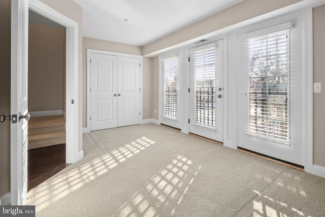 unfurnished bedroom with access to outside, light colored carpet, and a closet