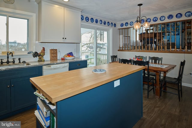 kitchen featuring blue cabinetry, dishwasher, and butcher block countertops